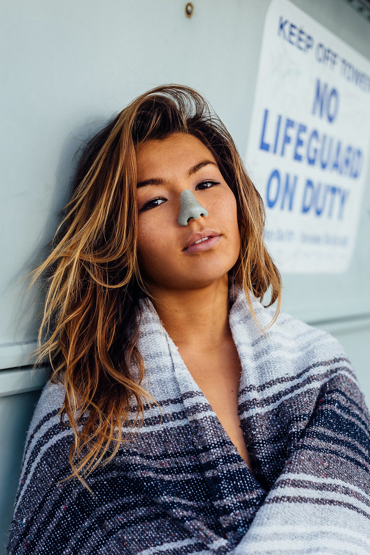 Woman wearing Nöz sunscreen in mint green.